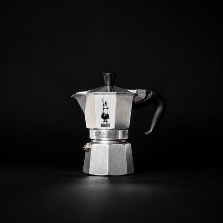Bialetti Moka Express Espressokocher aus Edelstahl mit Griff, für Kaffeezubereitung auf dem Herd, auf einem Küchenhintergrund.
